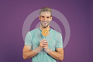 Taste of childhood. Man with bristle likes lollipop. Cheat meal concept. Sugar harmful for health. Guy hold lollipop