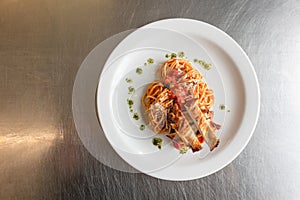 A Taste of Culinary Excellence: Spaghetti and Roast Chicken Delight Presented on a White Plate