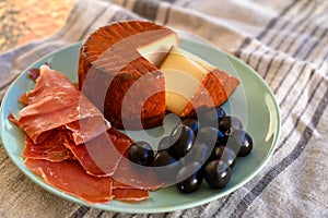 Tastes of Spain, jamon iberian, black olives and manchego cheese with red paprika