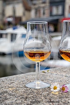 Tasting of apple calvados drink in old Honfleur harbour with boats and old houses on background, Normandy, France