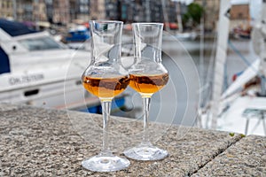 Tasting of apple calvados drink in old Honfleur harbour with boats and old houses on background, Normandy, France