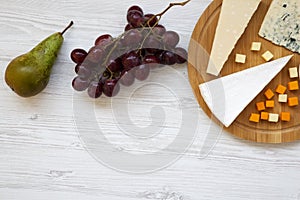 Tasting cheese with fruits on white wooden background. Food for wine, copy space. Flat lay.