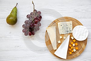 Tasting cheese with fruits on white wooden background. Food for wine, top view. Space for text.