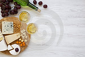 Tasting delicious cheese with wine, grapes, walnuts and pretzels on wooden background, top view. Food for romantic. From above.