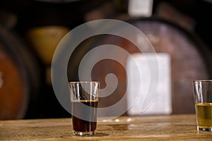 Tasting of different sweet wines from wooden barrels on old bodega in central part of Malaga, Andalusia, Spain