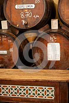 Tasting of different sweet wines from wooden barrels on old bodega in central part of Malaga, Andalusia, Spain