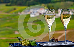 Tasting of french sparkling white wine with bubbles champagne on outdoor terrace with view on grand cru Champagne vineyards in photo
