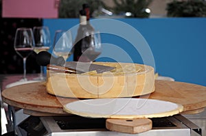 Tasting of a hard cheese wheel . Glasses of white and red wine with bottle for the corect drink and food pairing.