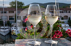 Tasting of local white wine in summer with sail boats haven of Port Grimaud on background, Provence, France