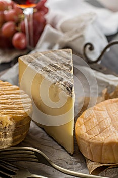 Tasting of oldest french AOC soft pudgent yellow cheese Livarot, Munster and semifirm Tomme french cheeses