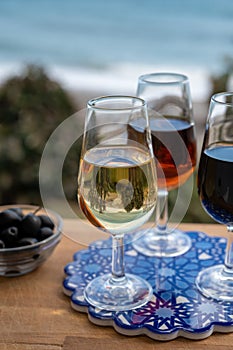 Tasting of Spanish sweet and dry fortified Vino de Jerez sherry wine and green olives with view on blue sea near El Puerto de photo