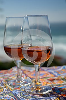 Tasting of sweet moscatel de setubal or porto portuguese wine and view on blue Atlantic ocean near Sintra in Lisbon area, Portugal