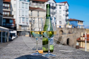 Tasting of txakoli or chacoli slightly sparkling very dry white wine produced in Spanish Basque Country photo