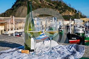 Tasting of txakoli or chacolÃ­ dry white wine produced in Spanish Basque Country with view on old port and