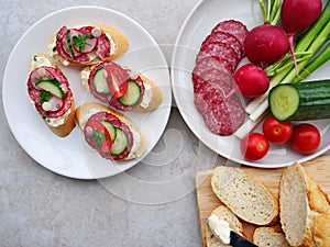 Tasty appetizers with cream cheese, salami and vegetables