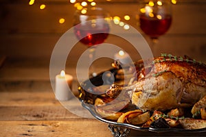 Tasty appetizing baked turkey with potato on wine glasses and candles background. Concept of festive Christmas dinner