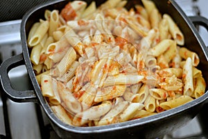 tasty appetizing classic pasta penne macaroni with tomato sauce, garlic, onion, spices, oil and black pepper, selective focus of