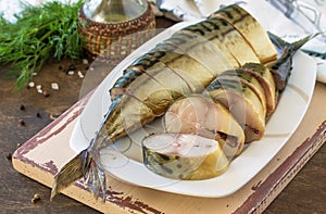 Tasty Appetizing smoked mackerel with spices on dark rustic wooden table