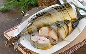 Tasty Appetizing smoked mackerel with spices on dark rustic wooden table. Copy space