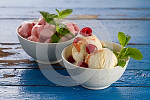 Tasty appetizing vanilla and strawberry ice cream with jam in bo