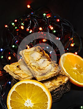 Tasty apple pie with oranges and christmas lights