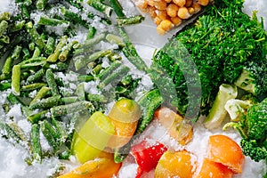 Tasty assortment of frozen berries, greens and veggies on grinded ice. top view.