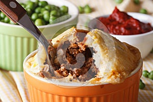 Tasty Australian meat pie in a pot on the table macro