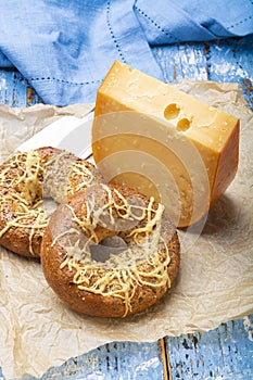 Tasty baked bagels with melted cheese and piece of aged Dutch Gouda cheese