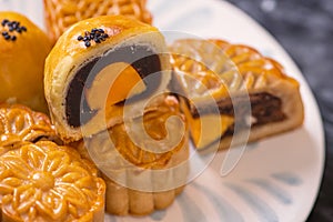 Tasty baked egg yolk pastry moon cake for Mid-Autumn Festival on black slate dark background. Chinese festive food concept, close