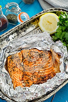 Tasty Baked Fish Salmon in Foil on Blue Table, Top View