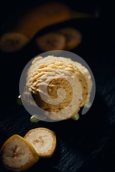 Tasty banana gelato scoop on blurred background