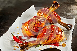 Tasty barbecued chicken legs with hot chili sauce