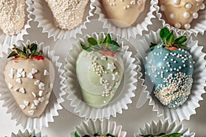 Tasty Blue chocolate dipped strawberries with sugar sprinkles on a parchment paper
