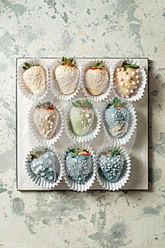 Tasty Blue chocolate dipped strawberries with sugar sprinkles on a parchment paper