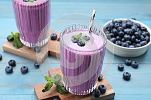 Tasty blueberry smoothie with mint and fresh berries on light blue wooden table