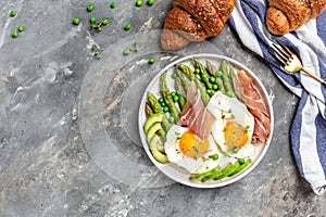 Tasty breakfast. avocado, asparagus, jamon, ham, prosciutto and fried egg on white plate. banner, menu recipe place for text, top