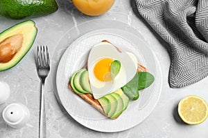 Tasty breakfast with heart shaped fried egg served on table, flat lay