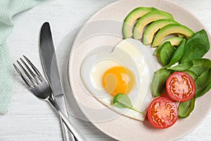 Tasty breakfast with heart shaped fried egg served on wooden table, flat lay