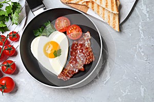 Tasty breakfast with heart shaped fried egg on table, flat lay