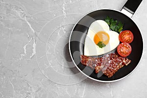 Tasty breakfast with heart shaped fried egg on table, top view. Space for text