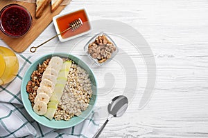 Tasty breakfast with oatmeal porridge on white wooden table, flat lay. Space for text