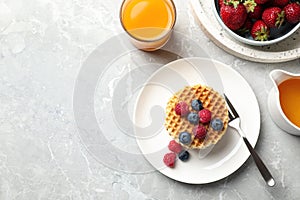 Tasty breakfast with wafers served on grey marble table, flat lay. Space for text