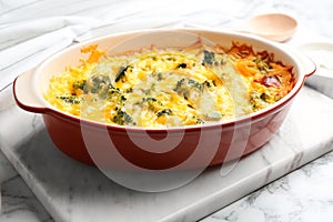 Tasty broccoli casserole in baking dish on white table photo