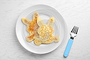 Tasty bunny shaped pancakes served on wooden table, flat lay. Creative idea for kids breakfast