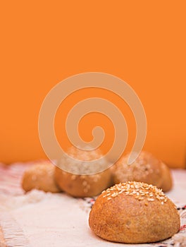 Tasty buns with sesame, on wooden background