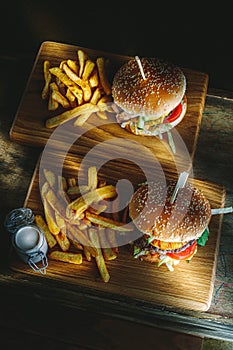 Tasty burger and french fries on wooden board
