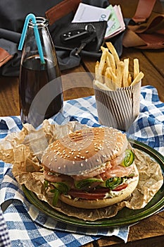 Tasty burger with salmon and french fries and soda