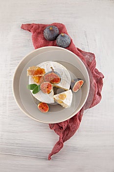 Tasty camembert with fresh figs and honey with honeycombs, decorated on a white wood plate background