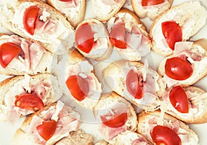 Tasty canapes with butter, ham and cherry tomatoes, food theme