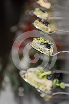 Tasty canapes plates in line hanging with caviar